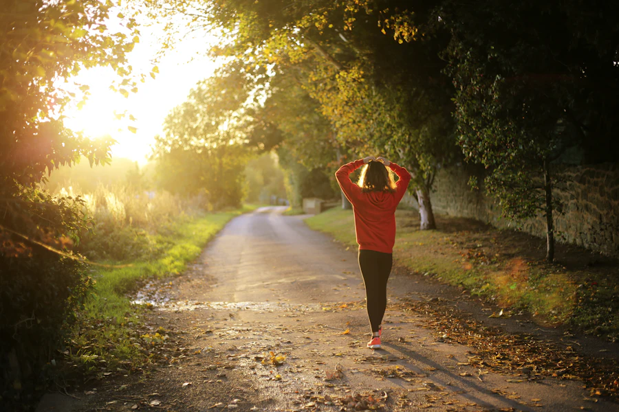 A woman walking alone along a sunlit country path